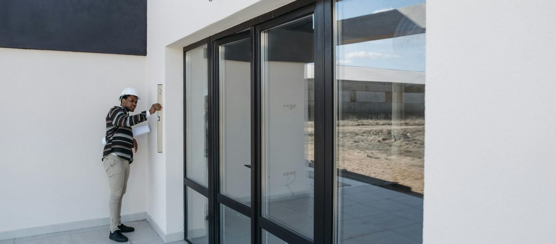 pexels-pavel-danilyuk-7937758 Homeowner securing windows with hurricane protection before storm season.